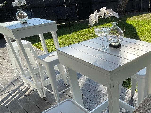 White bar table styled with an orchid centrepiece